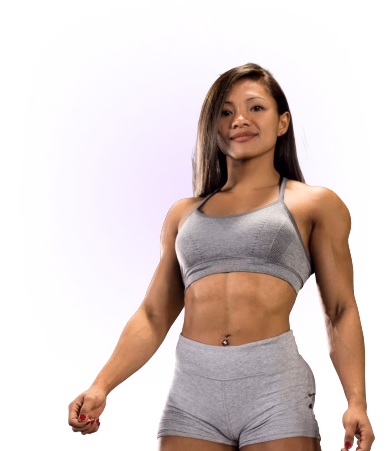 Fit woman wearing a gray sports bra and matching shorts standing confidently against a purple background.